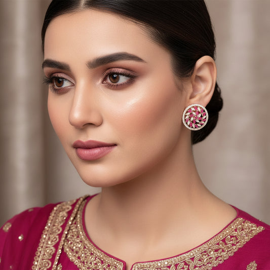 Pair of round earrings with pink and white gemstones on a gray background, featuring the brand 'Saheli'.