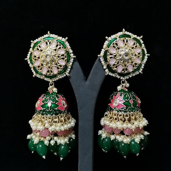 Ornate earrings with green, pink, and gold colors on a black background
