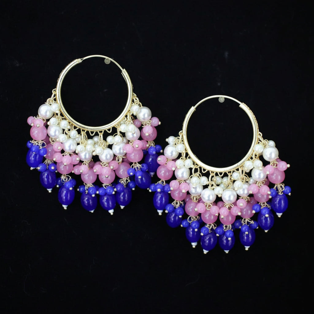 Pair of hoop earrings with blue and pink beads on a black background