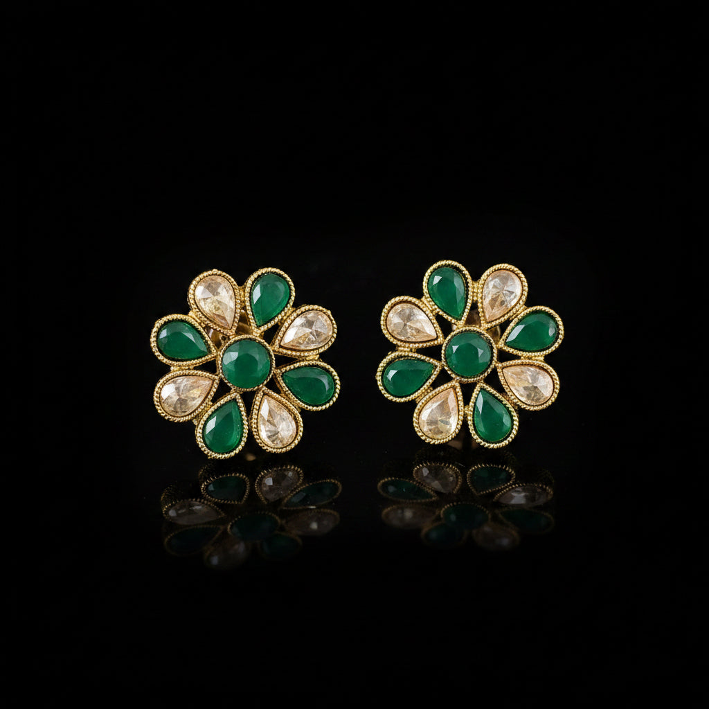 Pair of floral earrings with green and gold design on a gray background, featuring the brand 'Saheli'.