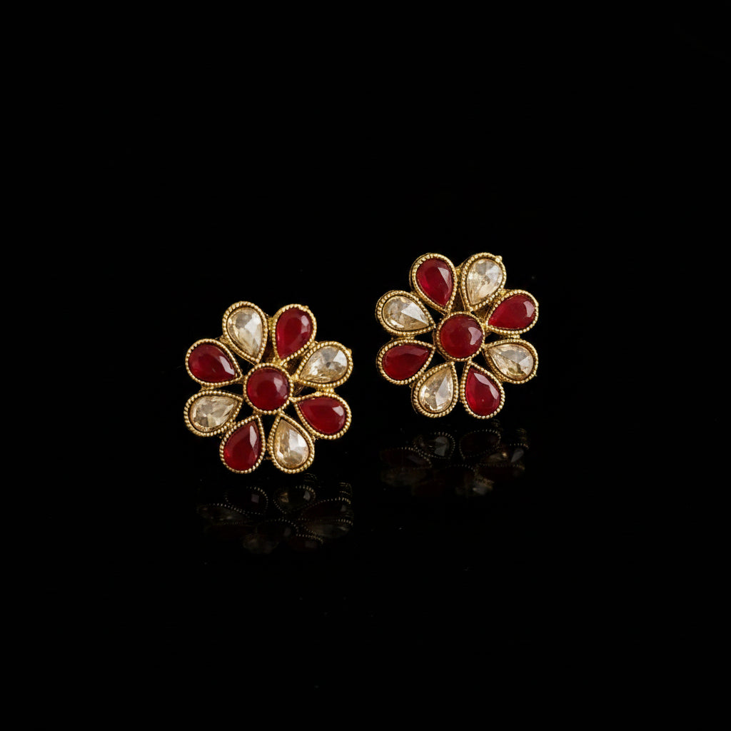 Gold and red floral earrings on a gray background with 'SAHELI' branding.