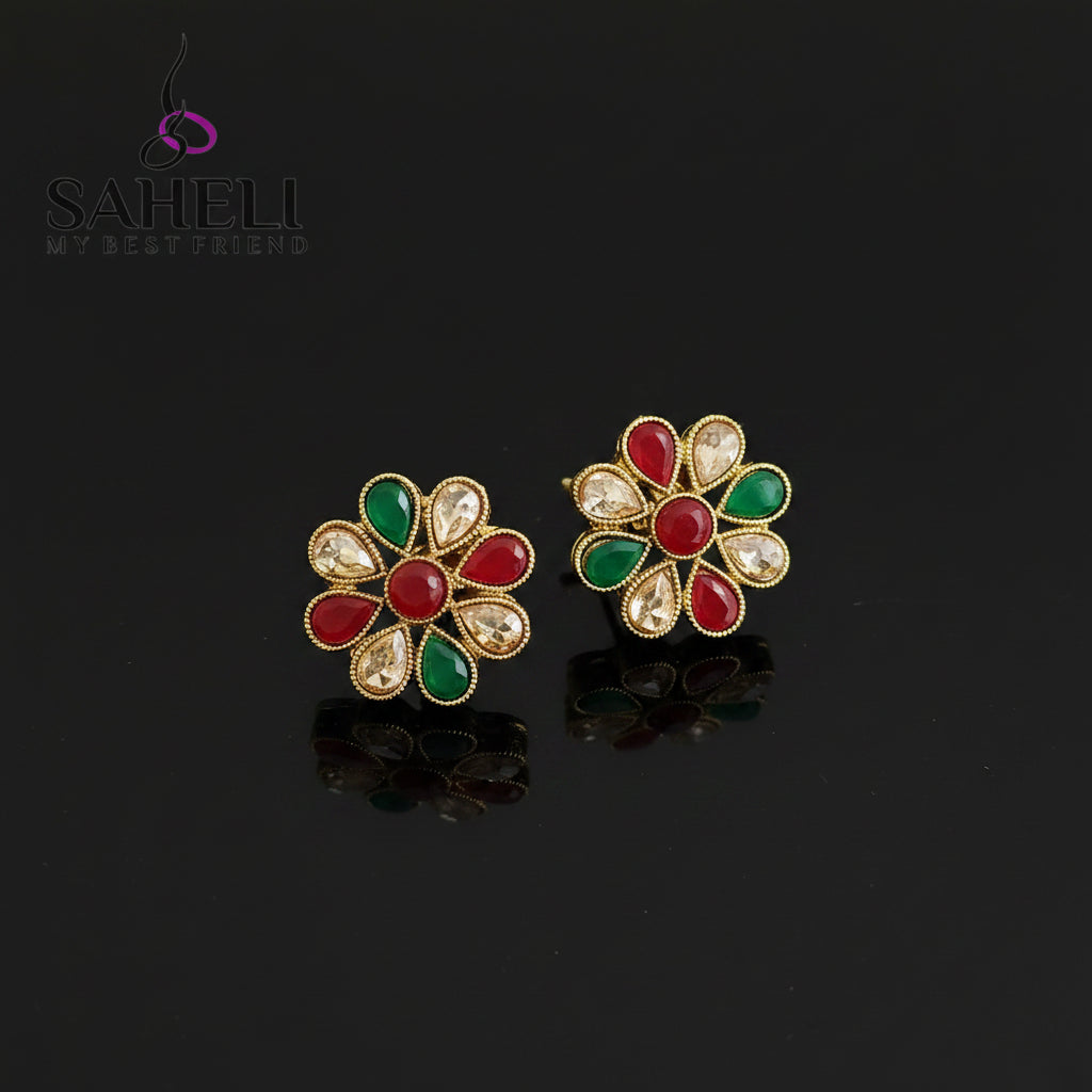 Colorful floral earrings with gemstones on a gray background, branded 'SAHELI'.
