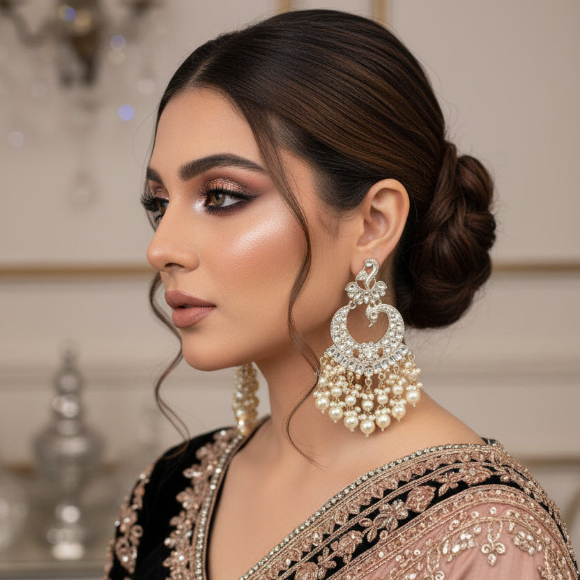Pair of ornate earrings with pearls on a dark background