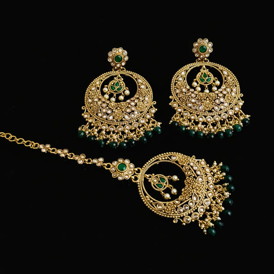 Gold necklace and earrings with green beads on a dark background, featuring the brand 'Saheli'.