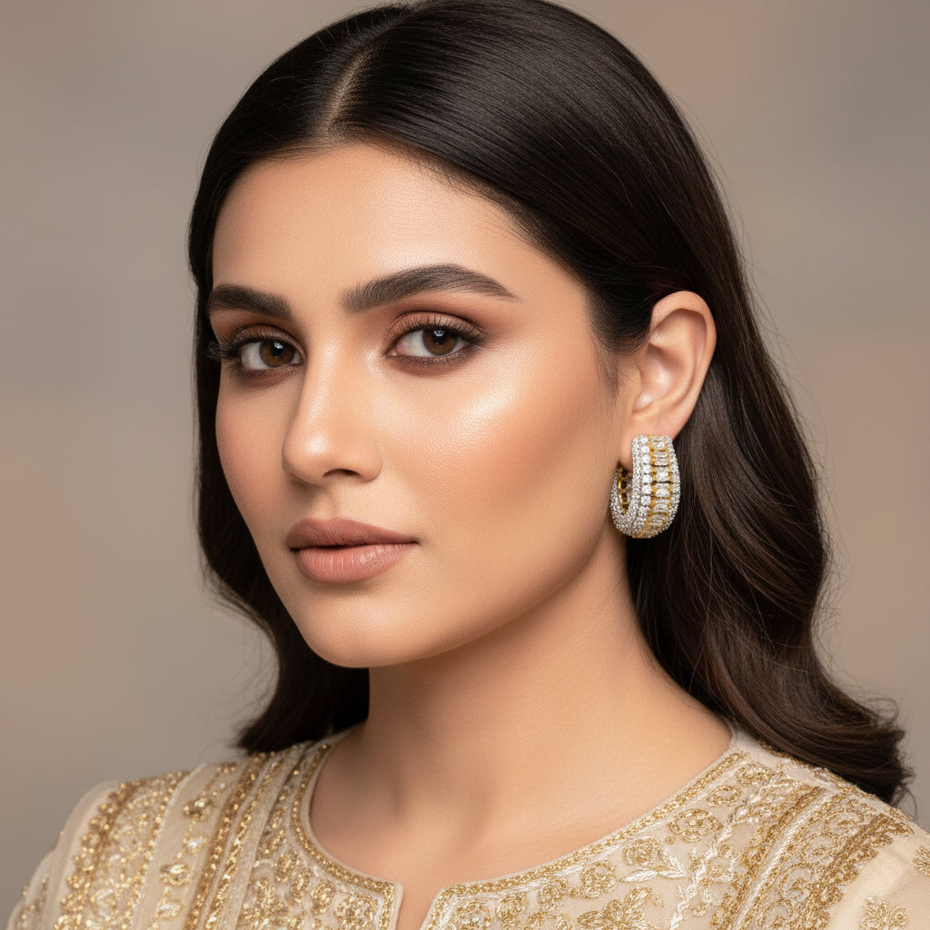 Gold and silver hoop earrings on a gray background with 'Saheili' branding.