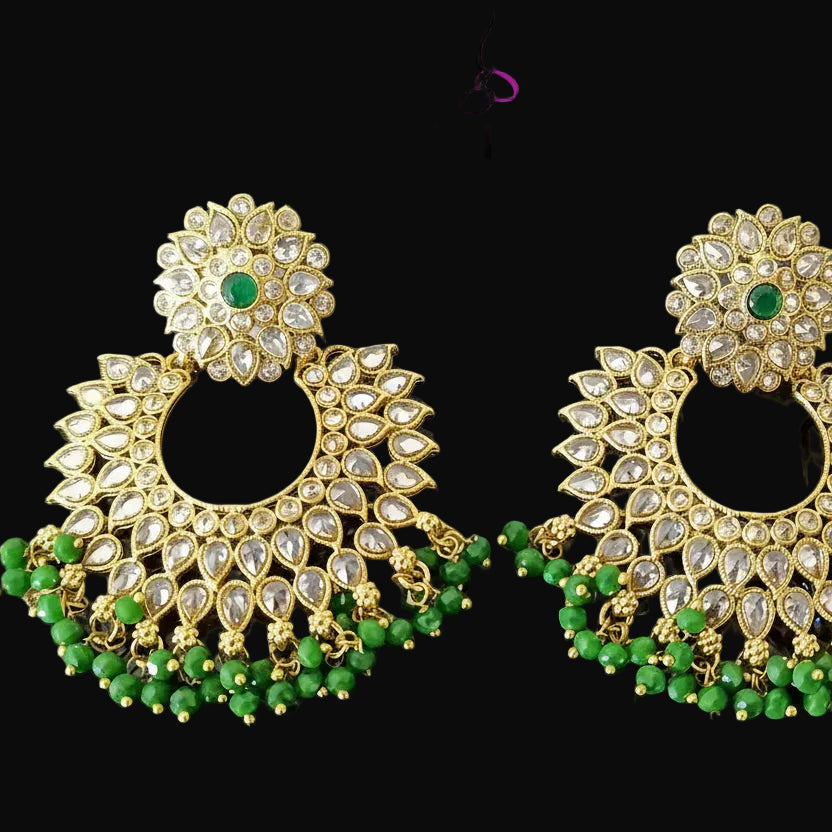 Gold and green earrings with 'SAHELI' branding on a dark background
