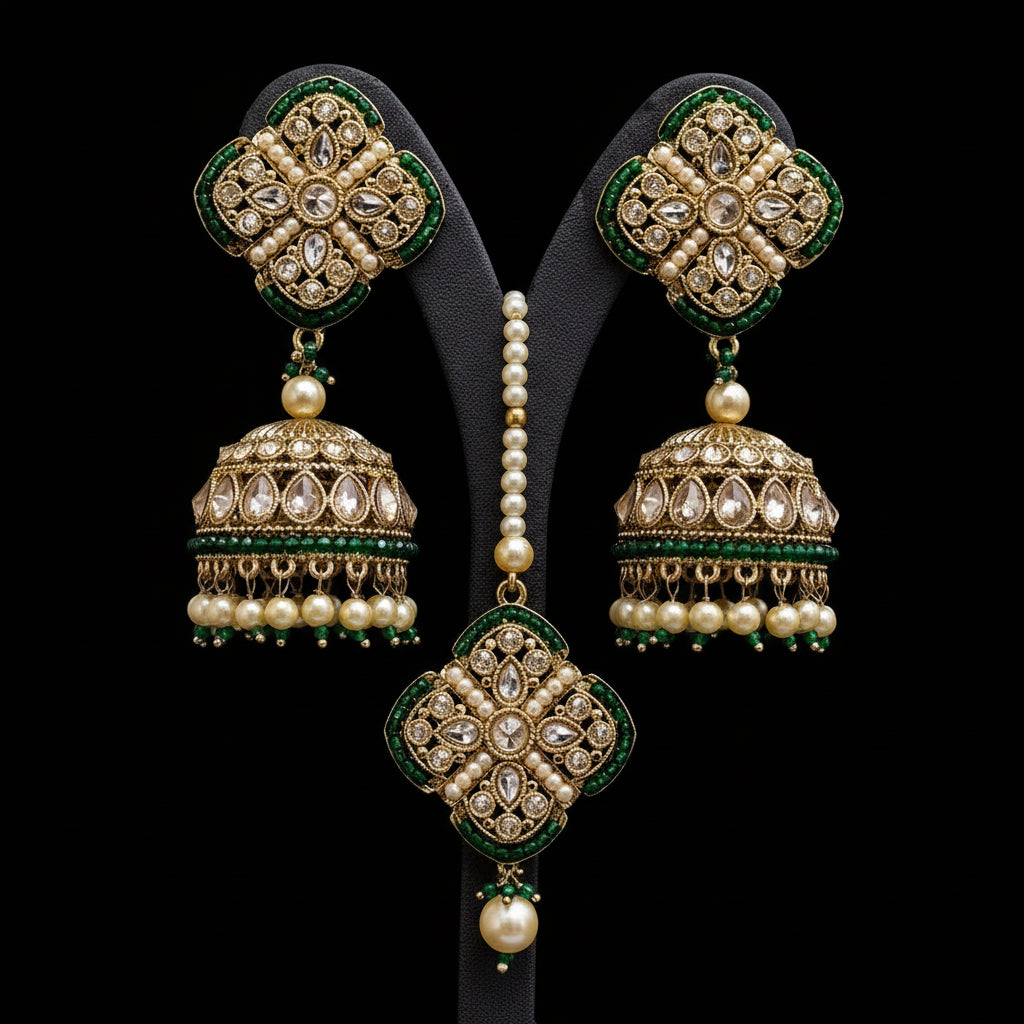 Ornate gold and green earrings with pearls on a gray background, featuring the brand 'SAHELI'.