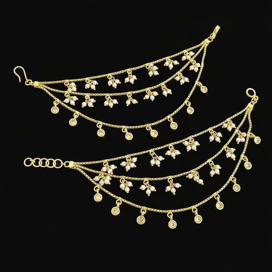 Gold necklace with floral pendants on a gray background, featuring the brand 'SAHELI'.