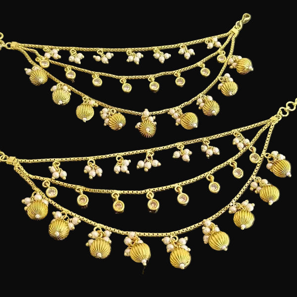 Gold necklace with pendants on a dark background, featuring the brand 'Saheli'.
