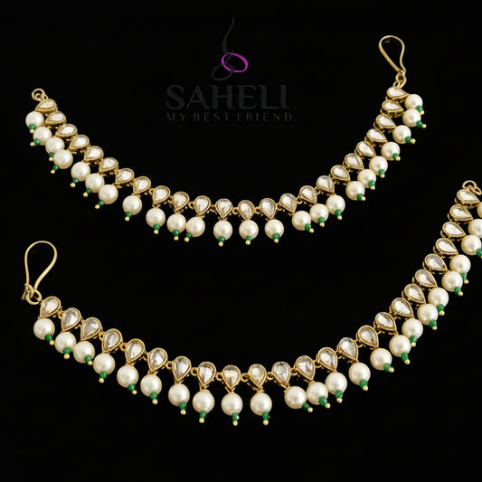 Pearl necklace with gold accents on a dark background, featuring the brand 'Saheli'.