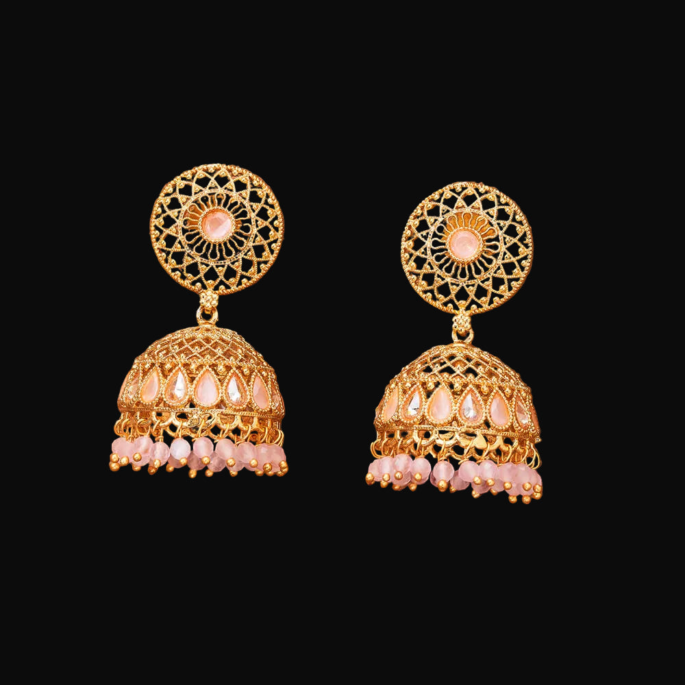 Gold and pink earrings on a brown background
