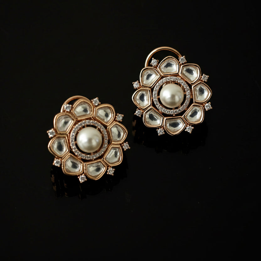 Pair of gold and pearl earrings on a black background