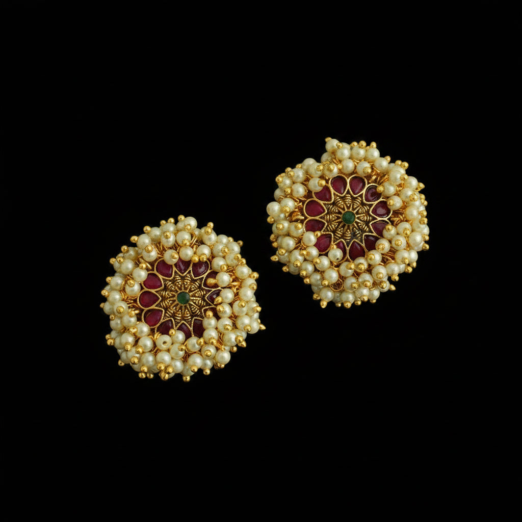 Pair of gold and pearl earrings on a dark background