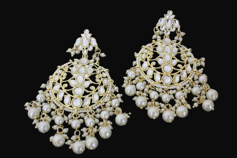 Pair of gold and pearl earrings on a dark background