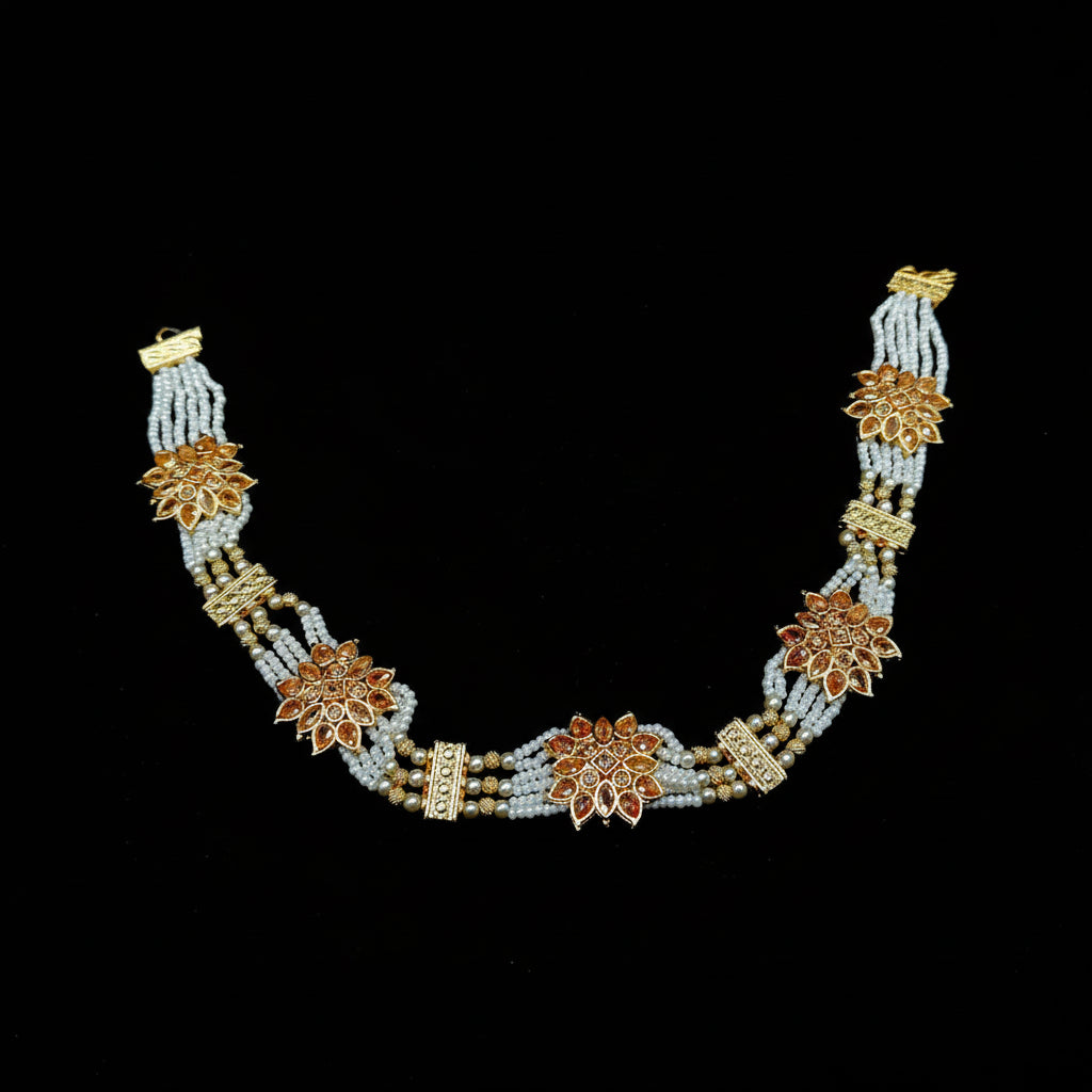 Decorative necklace with floral designs on a black background, featuring the brand 'Saheli'.