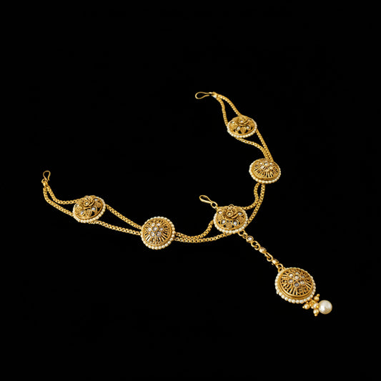 Gold necklace with decorative elements on a dark background