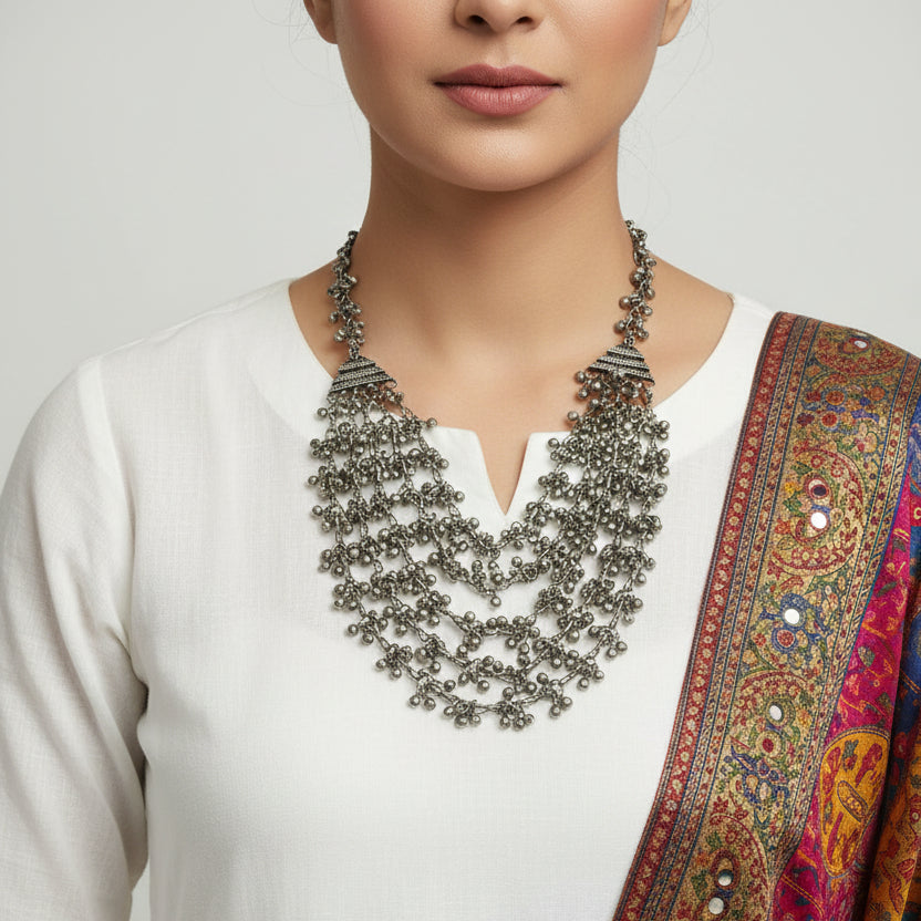 Silver beaded necklace on a dark surface