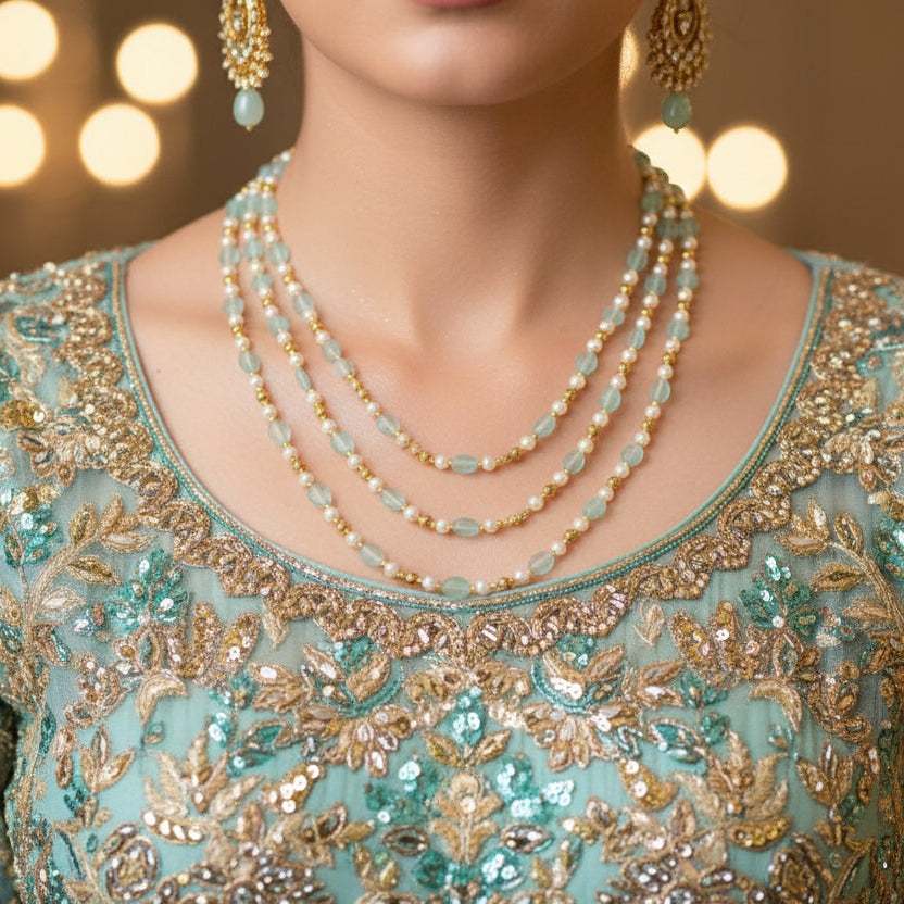 Beaded necklace with gold and green beads on a dark background