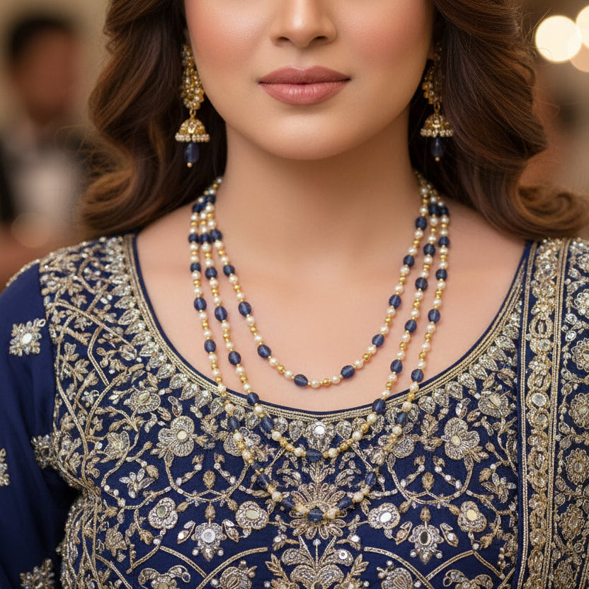 Beaded necklace with blue, gold, and white beads on a dark background