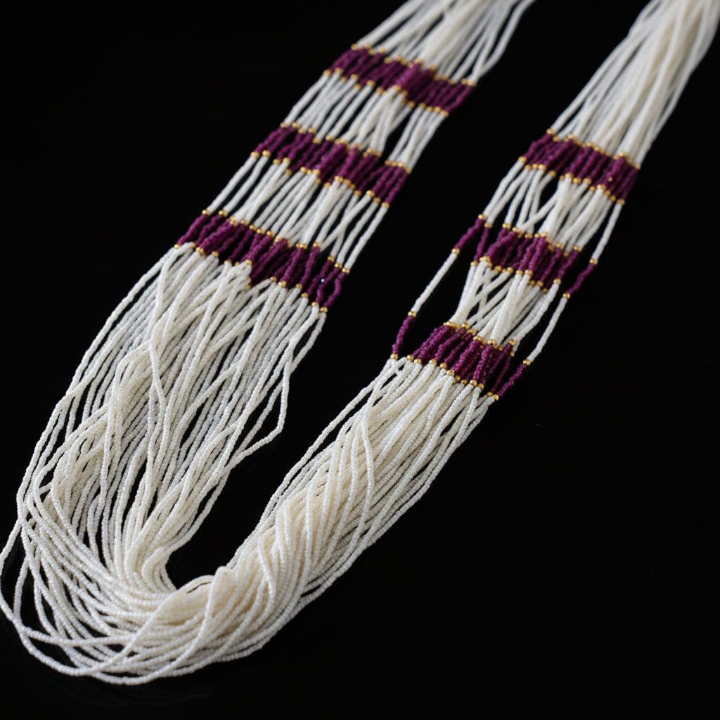 White beaded belt with purple and gold accents on a dark background