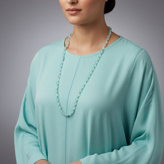 Necklace with light blue beads on a dark gray background