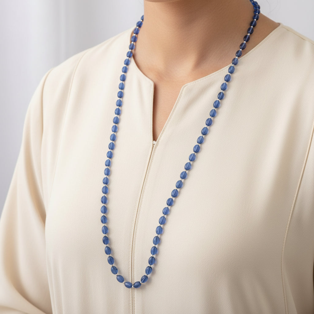 Blue beaded necklace on a gray background