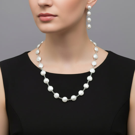 Pearl necklace and earrings set on a black stand with 'SAHELI' branding.