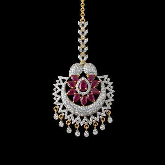 Ornate necklace with red gemstones on a dark background, featuring the brand 'Saheeli'.