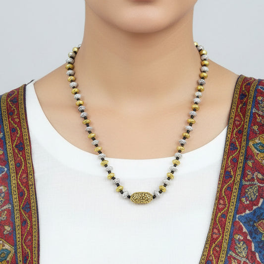 Necklace with gold, silver, and white beads on a gray background