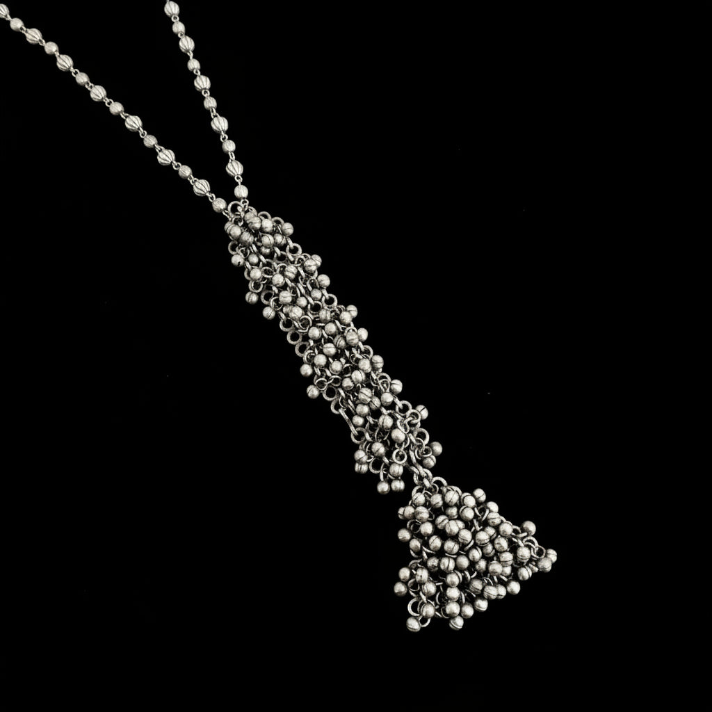 Silver beaded necklace on a plain background
