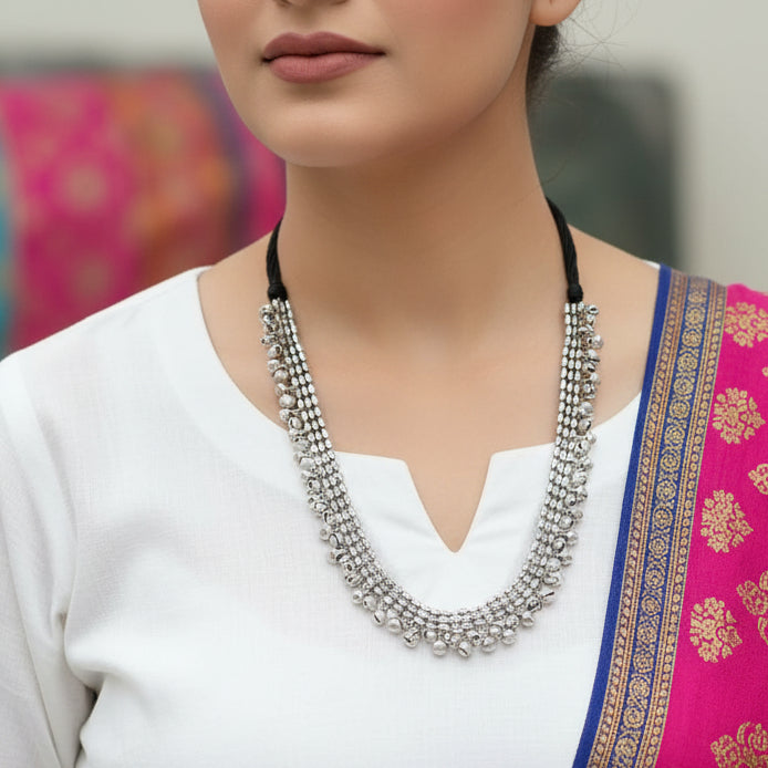 Silver beaded necklace on a dark surface