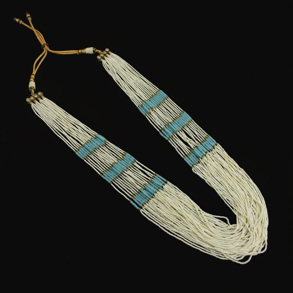 Necklace with white beads and blue accents on a dark background