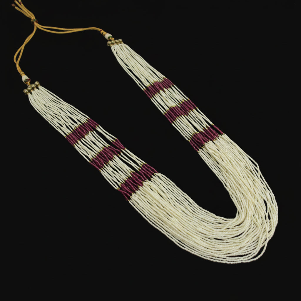 Necklace with white beads and purple accents on a dark background
