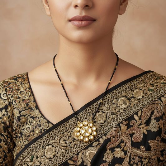 Gold and black beaded jewelry set featuring a necklace with a floral pendant and matching stud earrings, displayed on a dark reflective surface with a black stand. The brand name 'SAHELI JEWELLERYFRIEND' is visible in the top left corner.