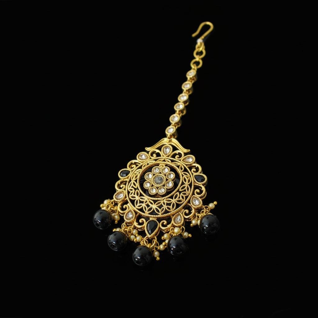 Gold necklace with black beads on a gray background, featuring the brand 'Saheli'.