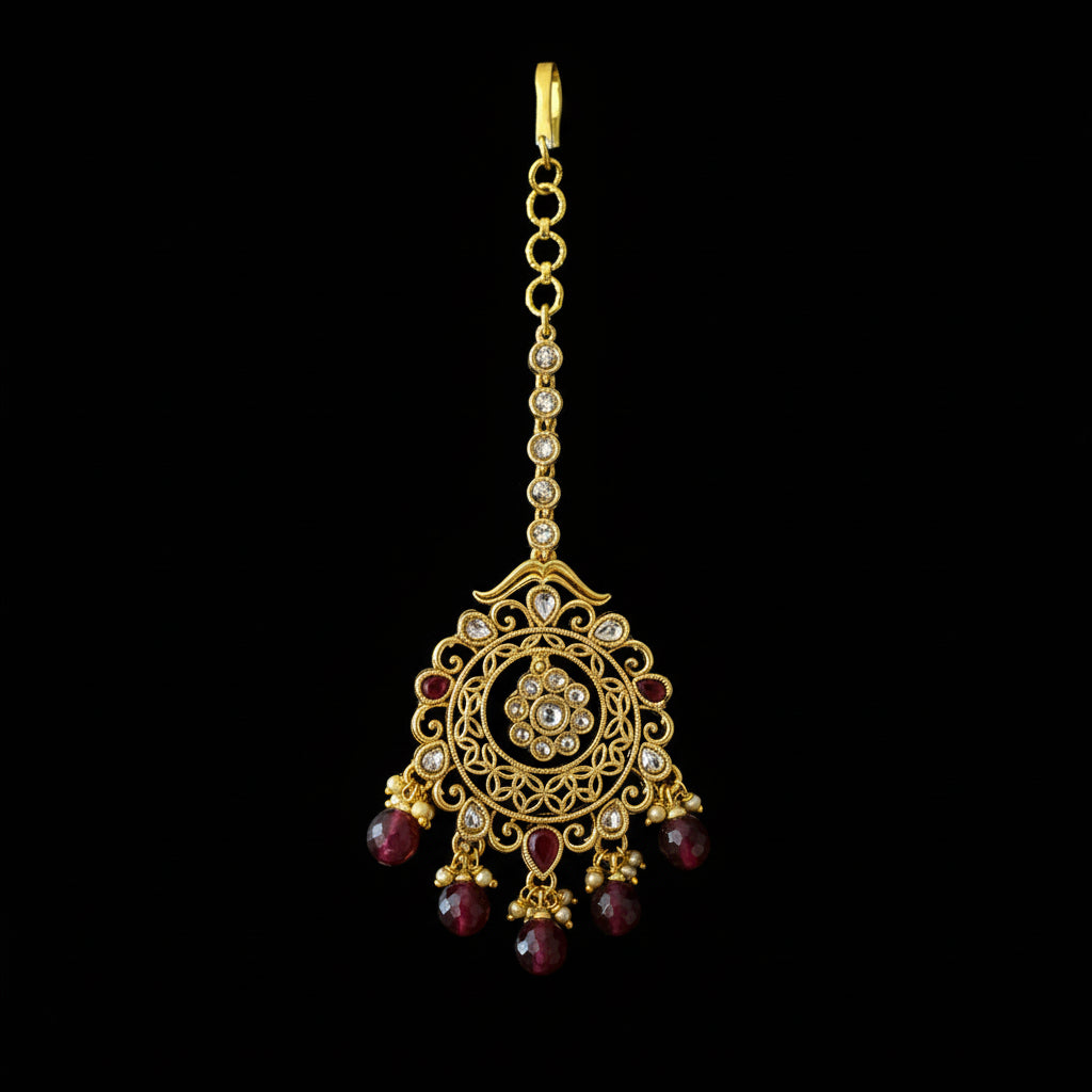 Gold necklace with red gemstones on a gray background, featuring the brand 'Saheli'.