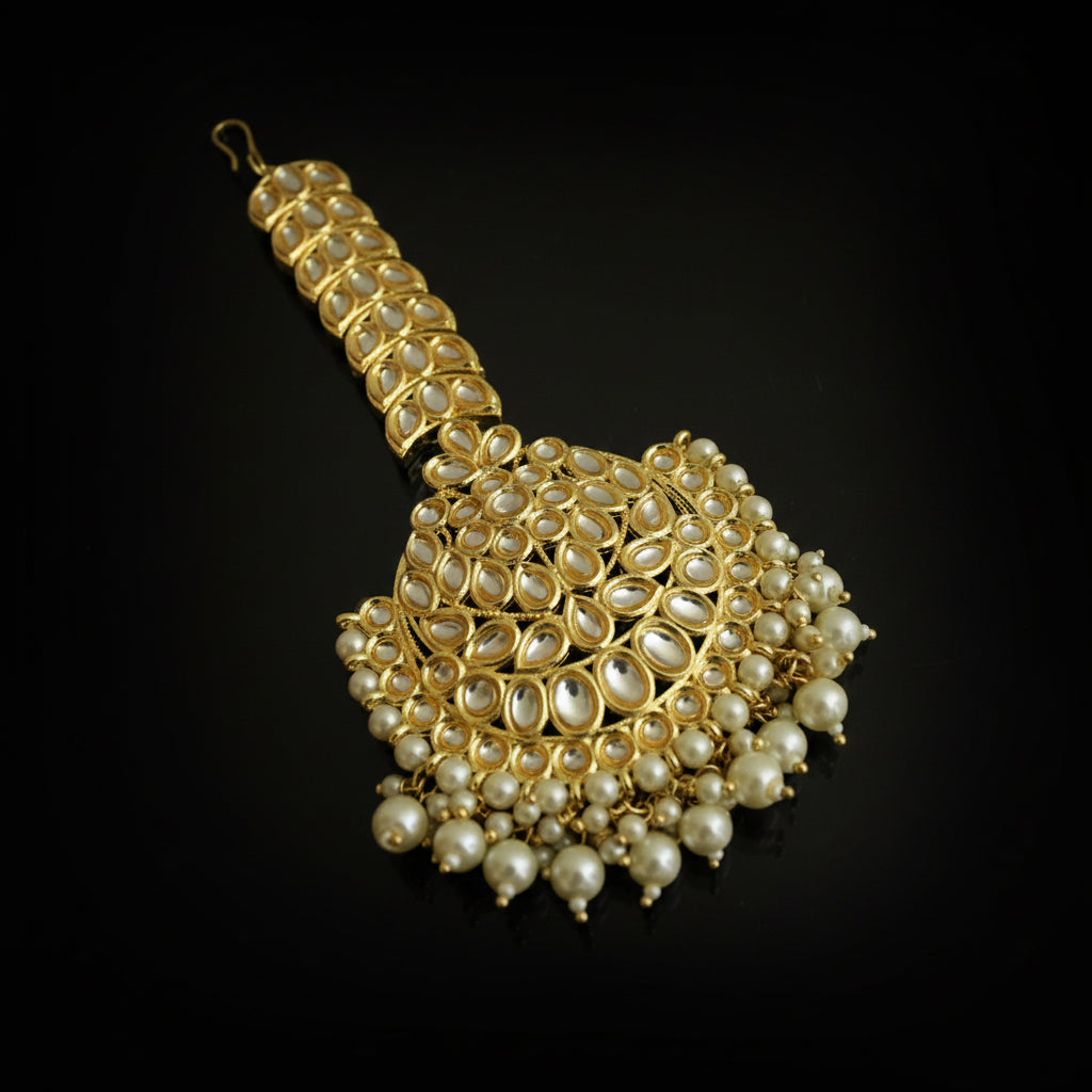 Gold and pearl decorative item on a black background