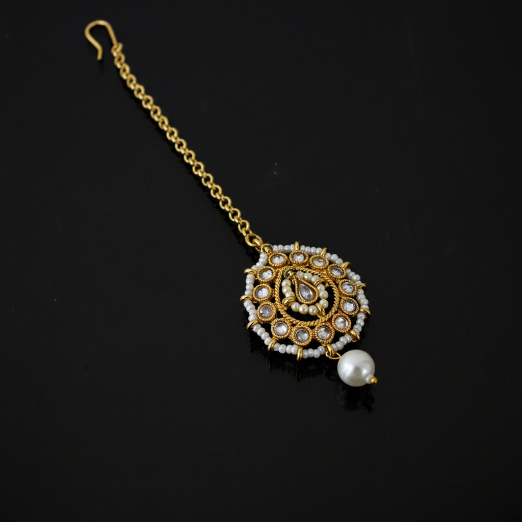 Decorative gold necklace with a pearl on a black background