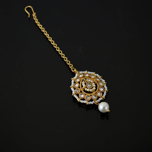 Decorative gold necklace with a pearl on a black background