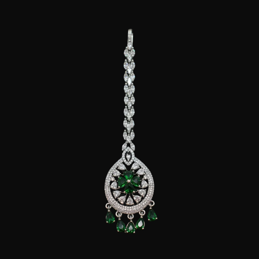 Jewelry with green gemstones on a gray background