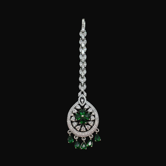 Jewelry with green gemstones on a gray background