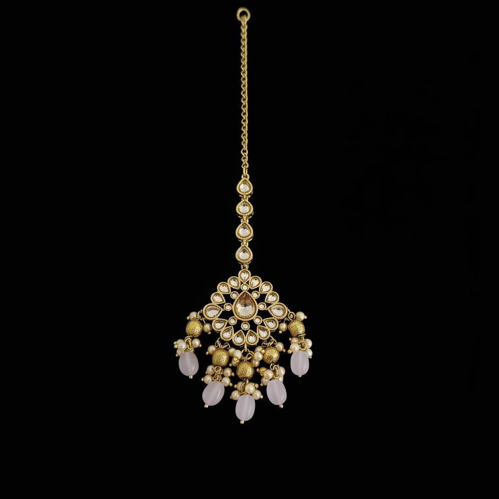 Gold and pink gemstone necklace on a dark surface