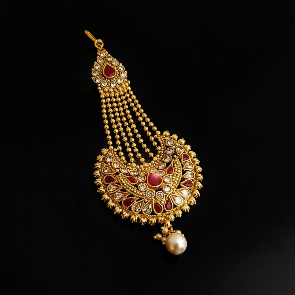 Gold necklace with red stones on a dark background, featuring the brand 'Saheli'.