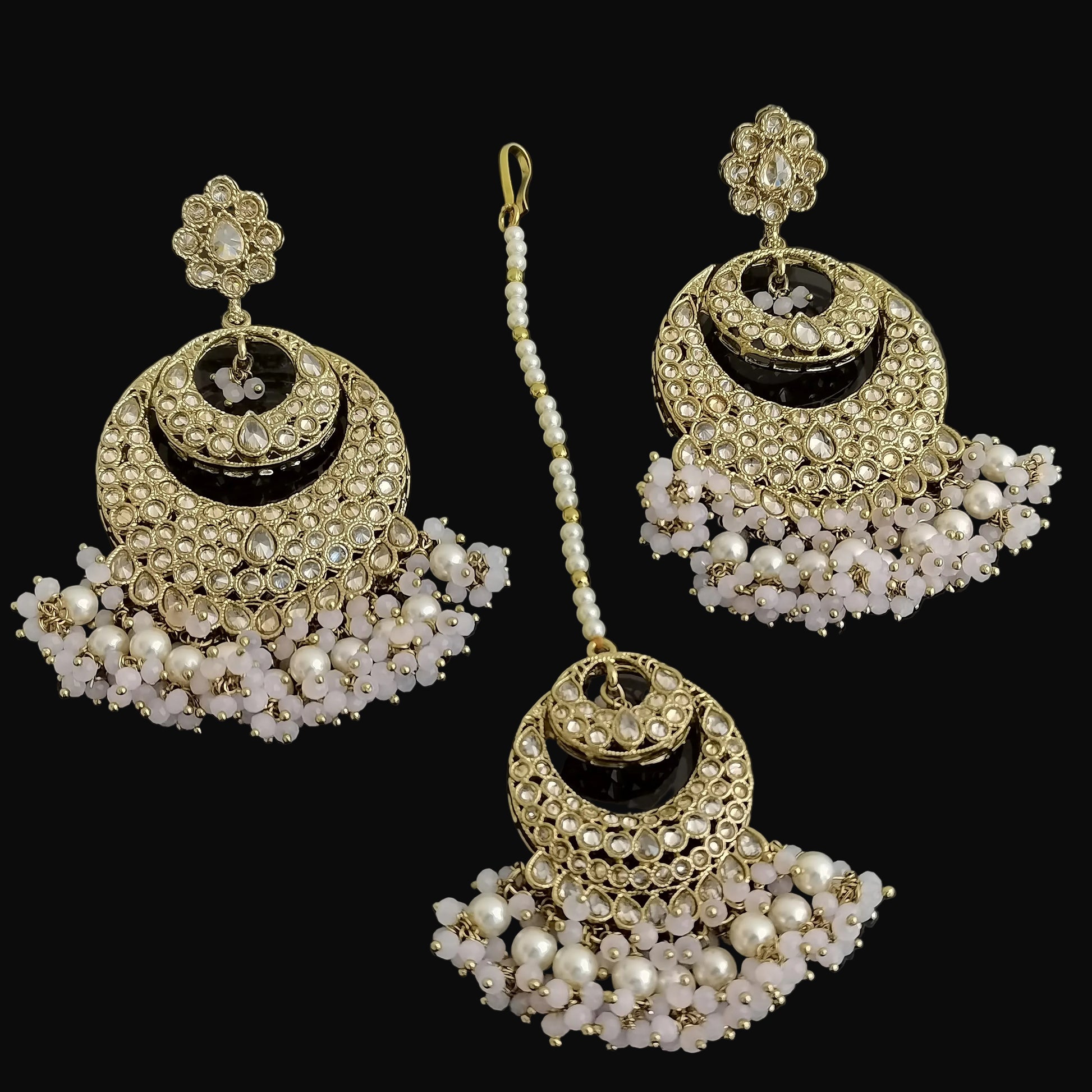 Set of gold and pearl earrings on a dark background