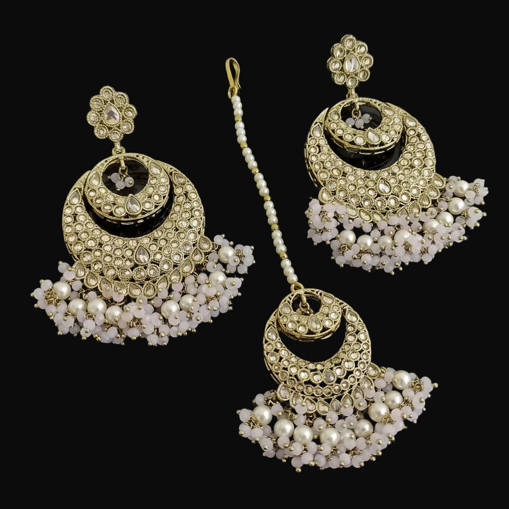 Set of gold and pearl earrings on a dark background