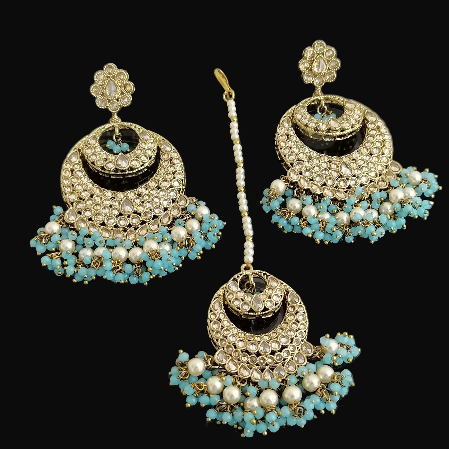 Jewelry set with earrings and a hairpin on a dark background