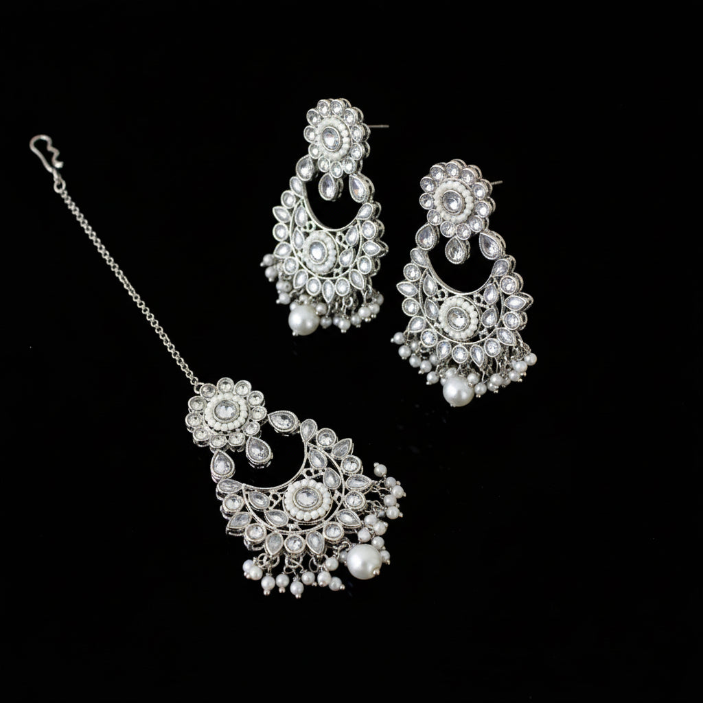 Silver jewelry set with floral designs on a dark background