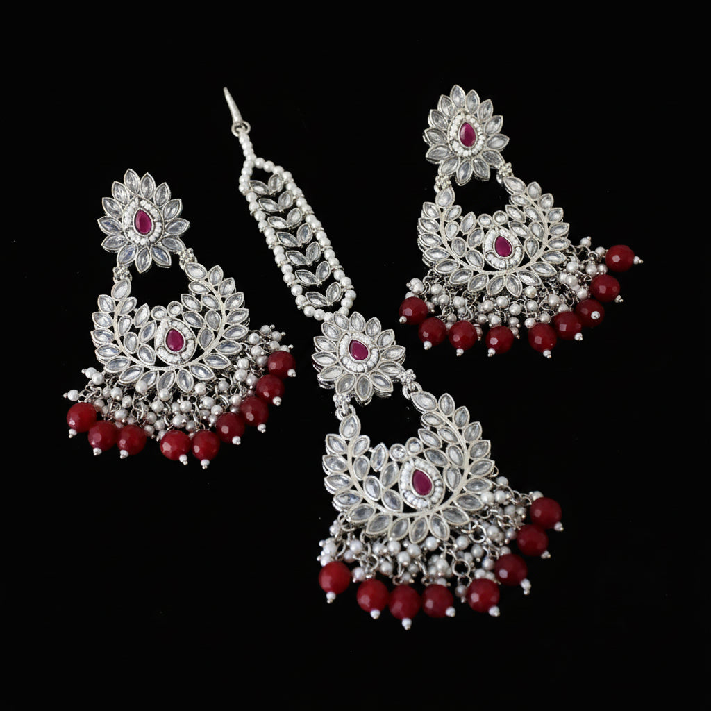 Pair of silver and red earrings on a dark background