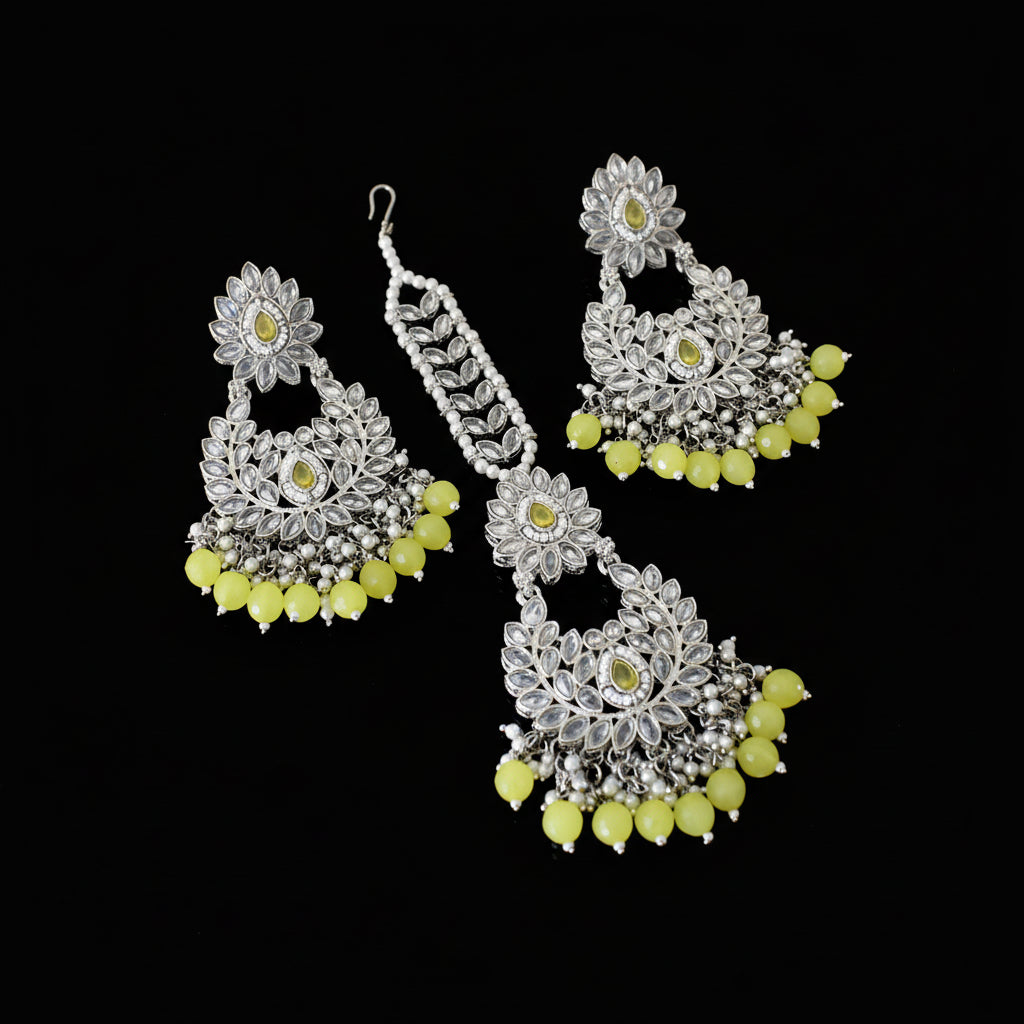 Silver and yellow floral earrings on a dark background