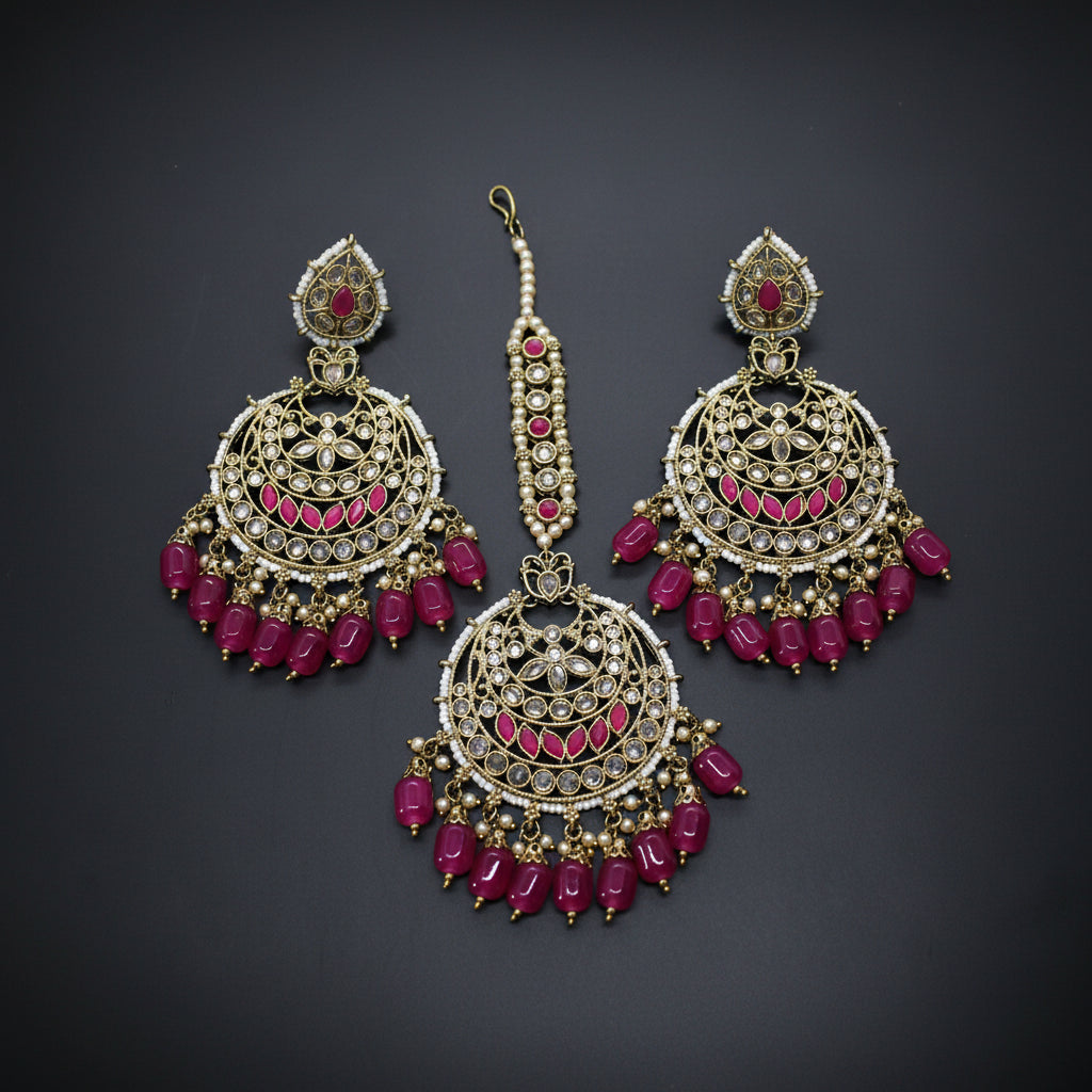 Ornate gold and pink jewelry set on a gray background